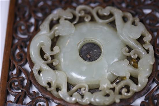 A Chinese archaistic pale celadon jade bi disc, 17th/18th century, Jade 8.3cm, frame 11cm x 12cm